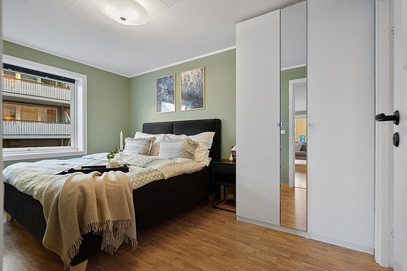 Soverom 2 - Lyst og innbydende hovedsoverom med god plass til dobbeltseng og garderobeskap. De grønne veggene skaper en rolig og avslappende atmosfære