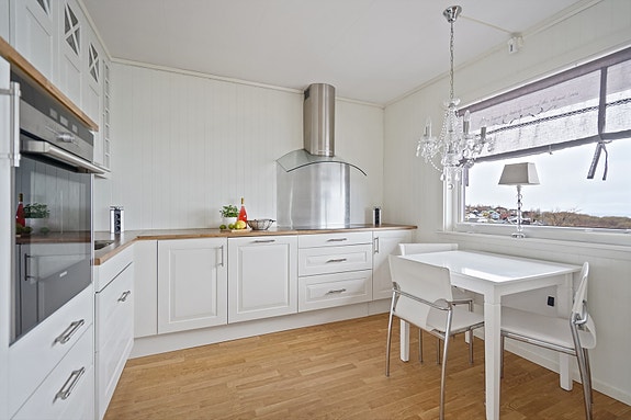 Kjøkkenet har lys innredning med profilerte fronter og benkeplate av laminat