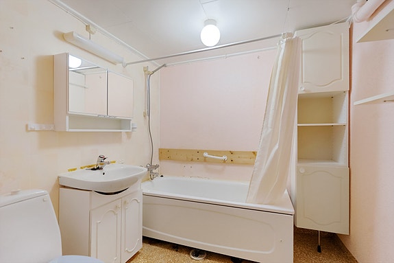 Bad kjeller utstyrt med servant, kombinert badekar og dusj, servant og oppbevaringsmuligheter