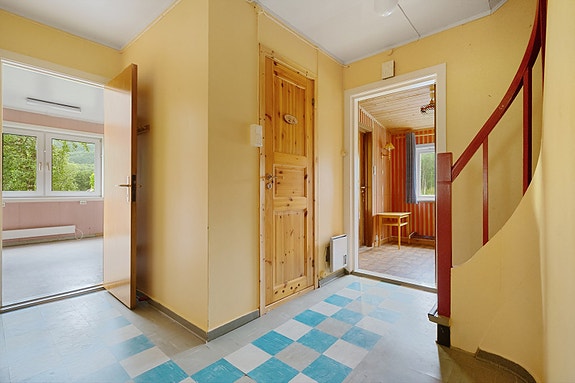 Lys hall med adkomst til flere rom og trapp til andre etasje