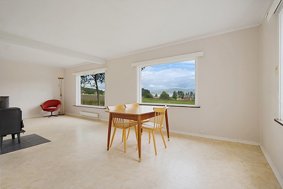 Romslig stue med store vindusflater som slipper inn rikelig med naturlig lys og gir flott utsikt mot nærområdet