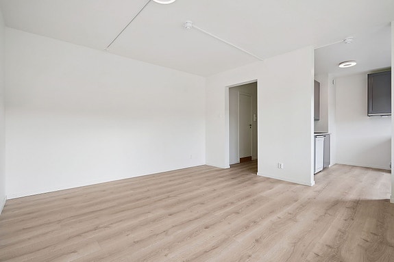 Åpen løsning mot kjøkken skaper en luftig romfølelse.