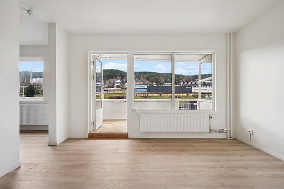 Stuen har åpen løsning mot kjøkken og utgang til balkong med utsikt.