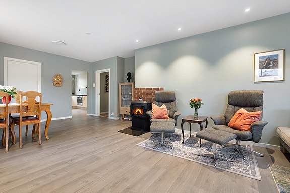 Romslig stue med god plass til både sofagruppe og spisestue - et naturlig samlingspunkt i hjemmet