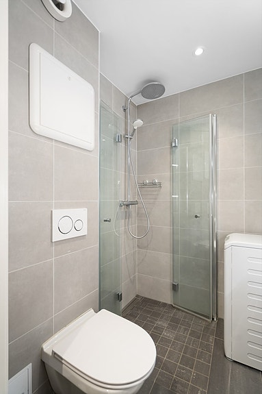 Dusjhjørne med glassdører og regndusj som gir en følelse av kvalitet i hverdagen