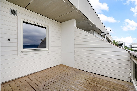 Balkongen er praktisk utformet med levegg som skjermer fra nabo og delvis overbygd