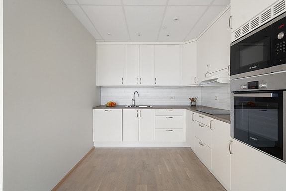 Tidløst kjøkken med lyse fronter, god skapplass og integrerte hvitevarer