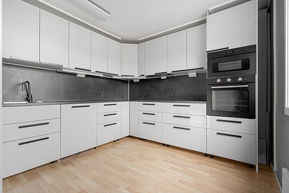 1.etg. - Stilrent kjøkken med hvite fronter og sorte detaljer som går igjen på kjøkkenet