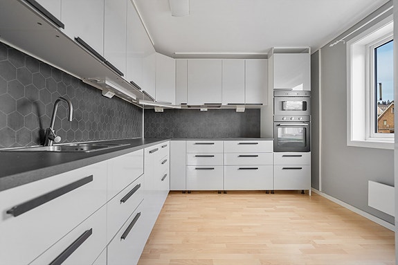 1.etg. - Kjøkkenet har gjennomtenkte detaljer som sorte håndtak, mørk grå benkeplate og sorte hvitevarer - rikelig med lysinnslipp fra vinduet skaper gode arbeidsforhold