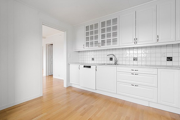 2.etg. - Kjøkken har en gjennomgående stil med hvite fronter, hvite fliser og hvit benkeplate