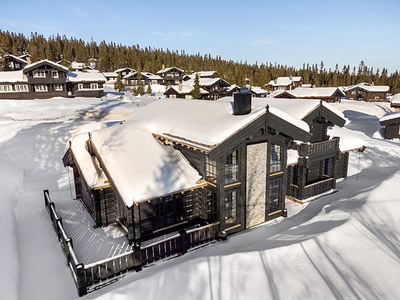 Fageråsen 805, en moderne laftehytte med fem soverom, tre bad, romslige oppholdsrom og solrike uteplasser med flott utsikt mot fjellene.