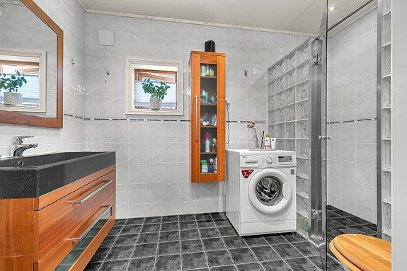 1. etg - Flislagt bad med dusjhjørne, god skapplass og opplegg for vaskemaskin - praktisk og funksjonelt
