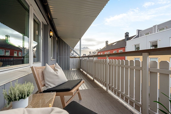 Fra balkongen har du utsyn mot nærliggende bygg og glimt av fjellene i bakgrunnen - en sentral, men fredelig plassering midt i sentrum av Narvik