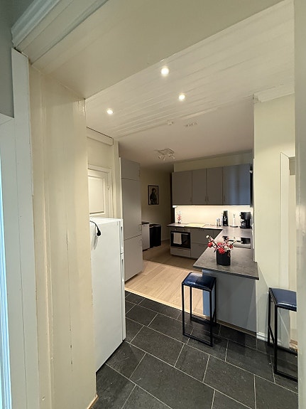 Kjøkken med to kjøleskap, platetopp, komfyr, oppvask maskin, diverse gryter og servise