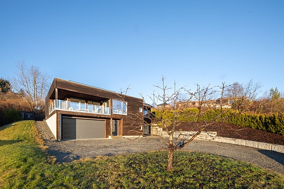 Moderne enebolig i funkisstil med sekundærleilighet og takterrasse