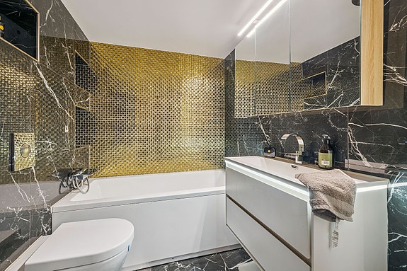 Bad med frittstående badekar og elegant baderomsinnredning.