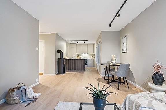 Åpen løsning mot kjøkkenet skaper en sosial og innbydende atmosfære.