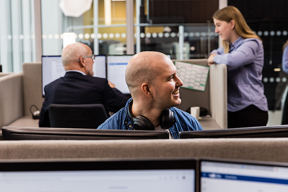 Medarbeider som sitter foran arbeidspulten