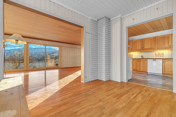 Romslig hall med åpning mot stue og kjøkken.