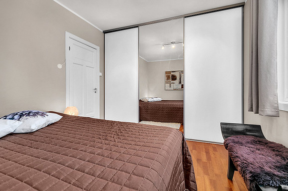 Hovedsoverom med stor skyvedørsgarderobe.