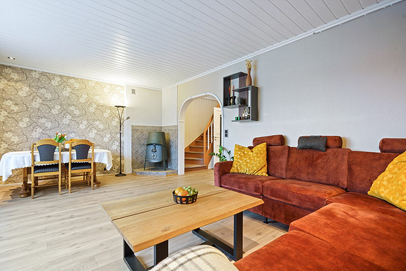 Stuen har plass til møblering i flere soner, og har også en vedovn som varmer godt.