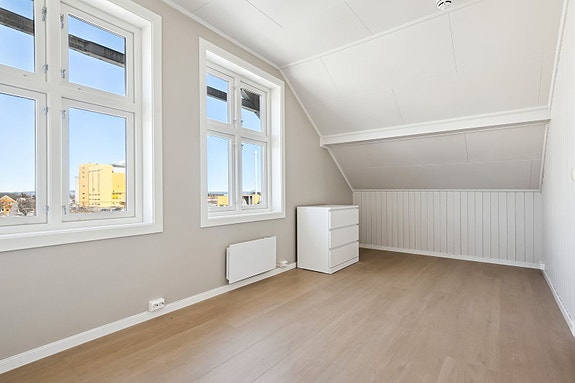 Trivelig stue med store vindu som slipper inn mye naturlig lys.