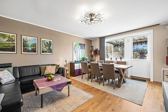 Stuen er malt i en behagelig farge og har plass til både sofakrok og en hyggelig spisestue.