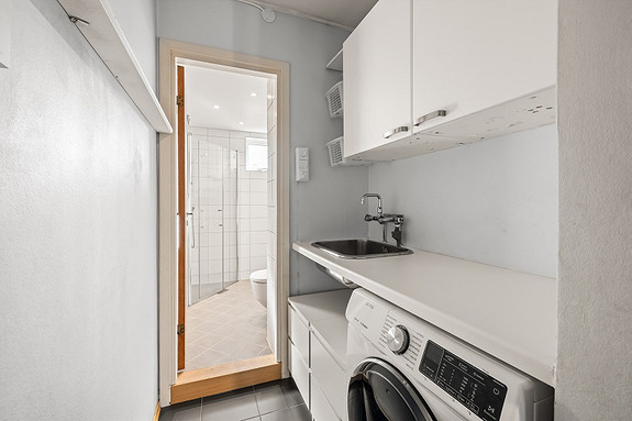 Moderne baderomsinnredning med opplegg for vaskemaskin.