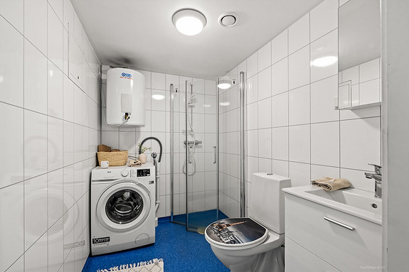 Moderne baderomsinnredning med opplegg for vaskemaskin.