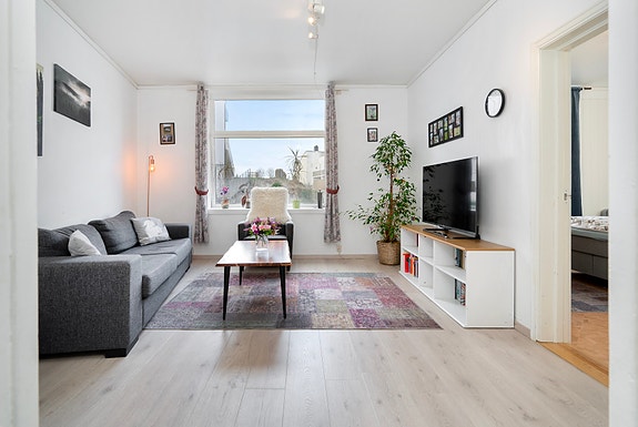 Lys og fin stue som er enkel å møblere.