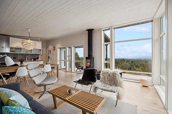 Innbydende oppholdsrom med åpen løsning mellom stue og kjøkken.