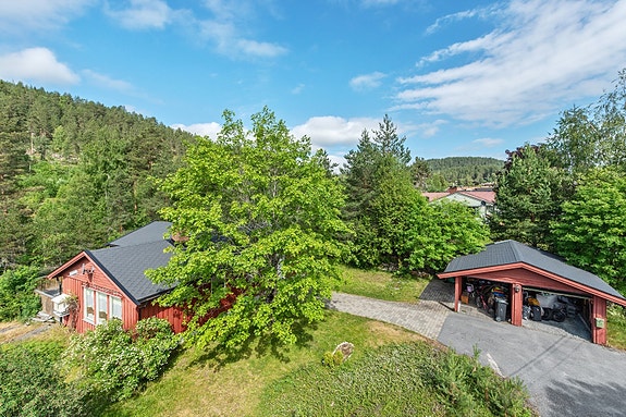 Parkering skjer i garasje og carport på asfaltert gårdsplass.