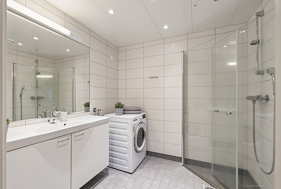 Moderne baderomsinnredning med opplegg for vaskemaskin.