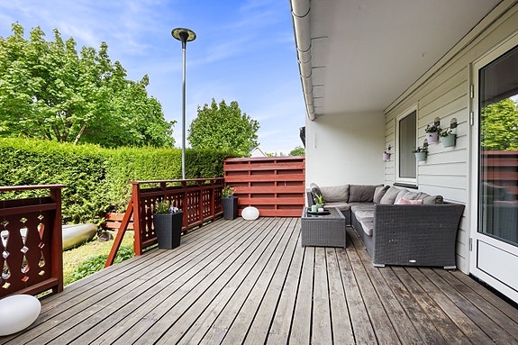 Her får du en stor terrasse platting som er godt skjermet fra innsyn og med kveldssol, samt en liten hageflekk.