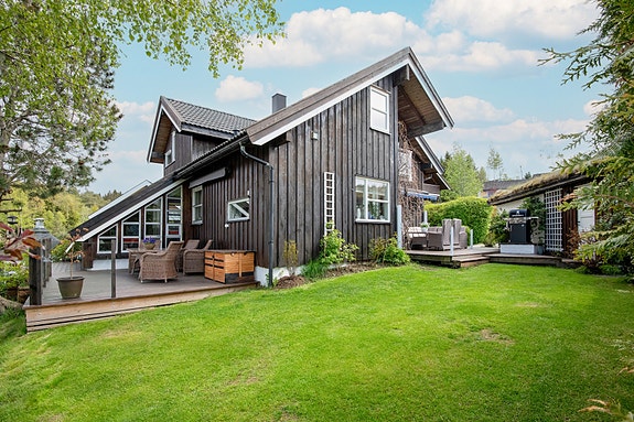 Boligen har en fin og velstelt hage med garasje, steinlagt gårdsplass og grillhytte.