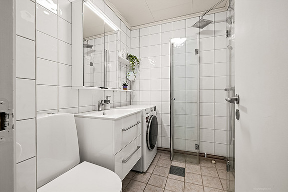 Moderne baderomsinnredning med opplegg for vaskemaskin.