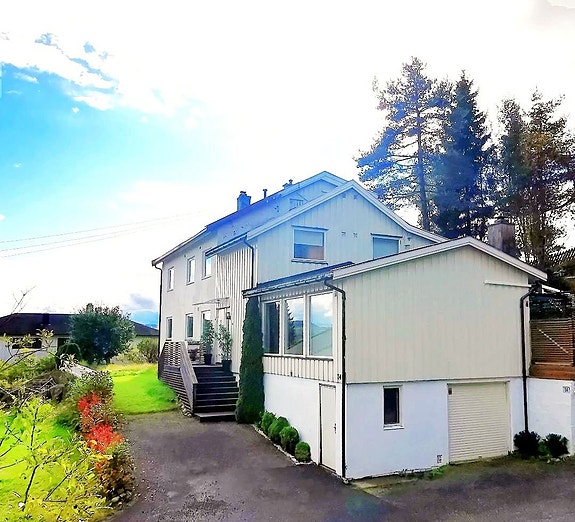 Velkommen til Gimleveien 14! En sjarmerende halvpart over en flate med frodig hage, usjenert terrasse og fin utsikt.