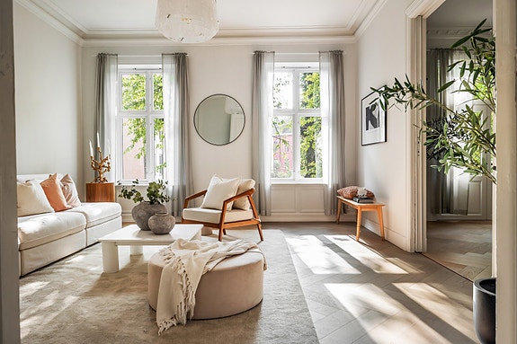 Stuen er et elegant rom med generøs takhøyde på omtrent 3,20 meter og vakre klassiske detaljer som stukkatur og rosetter.