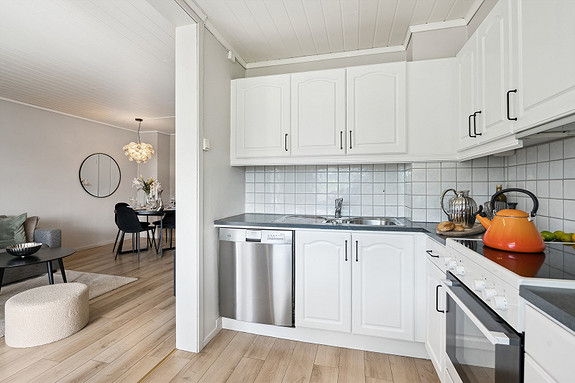 Stilrent og moderne kjøkken med hvitevarer.