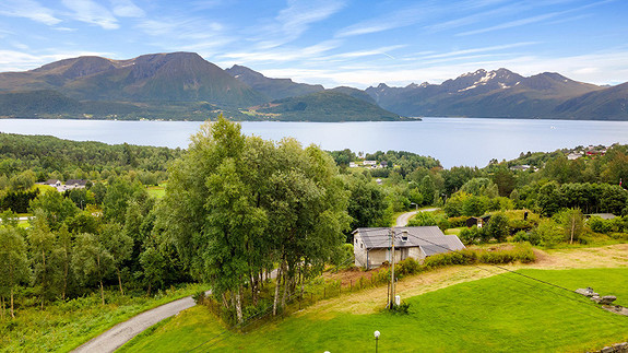 Dronebilde tatt fra nord mot syd med flott utsikt over fjord og fjell
