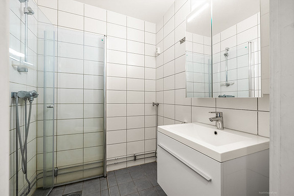 Moderne baderomsinnredning med opplegg for vaskemaskin.