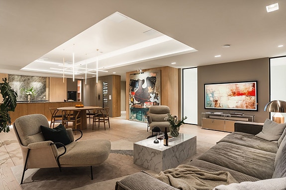 Stuen har stor plass til sofagruppe og loungestoler, perfekt for sosiale sammenkomster.