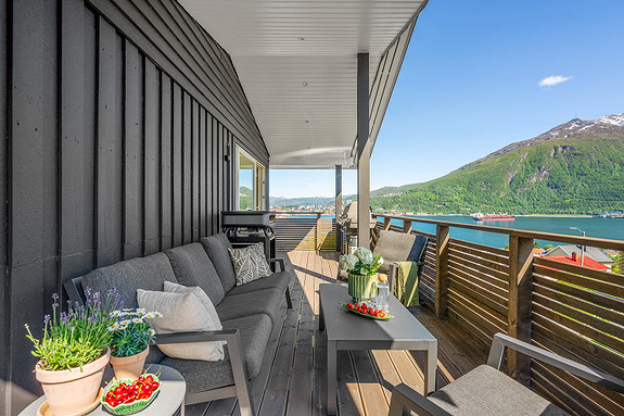 Overbygd veranda med god plass for utemøbler og grill