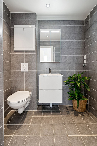 Moderne baderomsinnredning med opplegg for vaskemaskin.