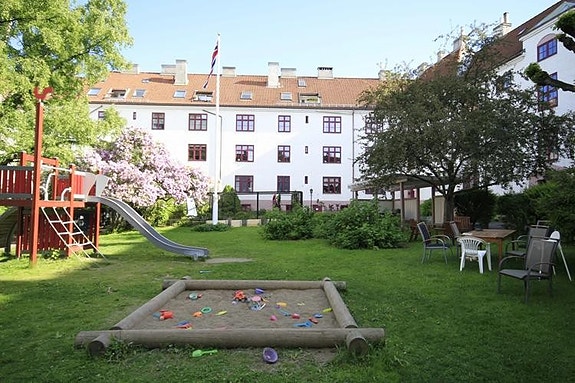 Hyggelig opparbeidet bakgård med grøntaeraler, lekeplass og sittegrupper