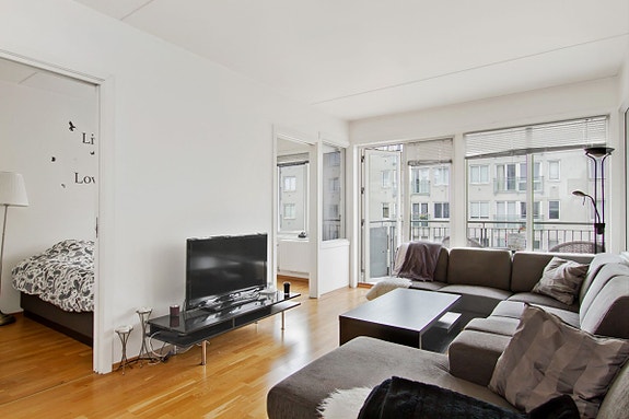 Lys stue med praktisk planløsning og store vindusflater.