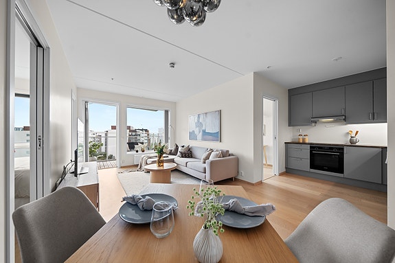 Kjøkkenet er delvis adskilt fra stuen og skaper en åpen, men samtidig privat atmosfære.