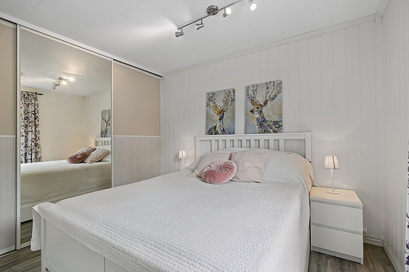 Soverommet er malt i lyse farger og har en praktisk, integrert skyvedørs garderobe.