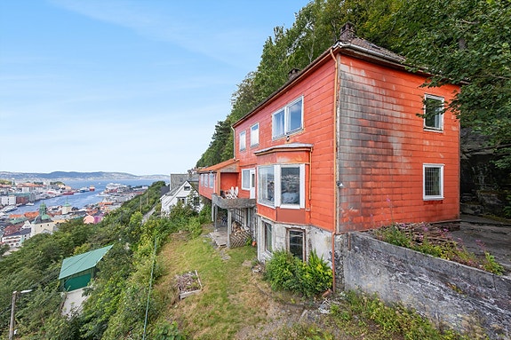 Stort bolighus i Fjellsiden med behov for full oppussing. Det er to boenheter og innredet kjeller.