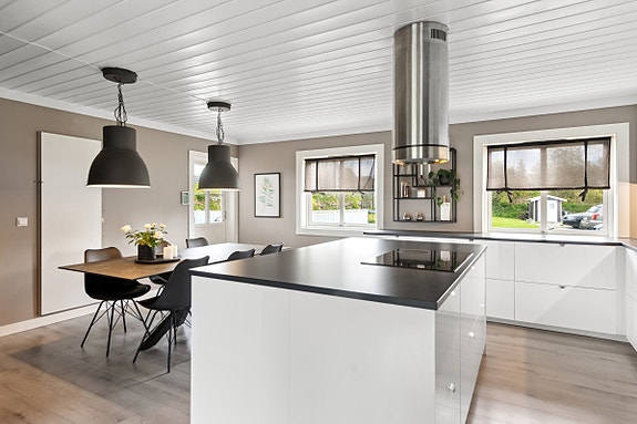 Lyst og romslig kjøkken med god plass til spiseplass. Praktisk kjøkkenøy hvor koketopp og ventilator er plassert